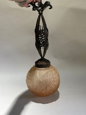 a person that is holding a glass vase with a bird on it