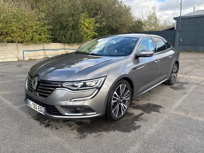 La voiture grise est garée sur un parking près d'un immeuble.
