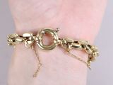 gold plated bracelet with a chain and a clasp on a woman ' s wrist
