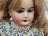 a close up of a doll with long blonde hair