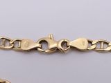 a close up of a gold chain bracelet on a white surface