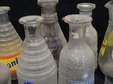 bottles of various sizes and colors are lined up on a table