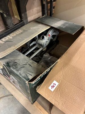 une boîte en carton contenant une machine, posée sur une palette