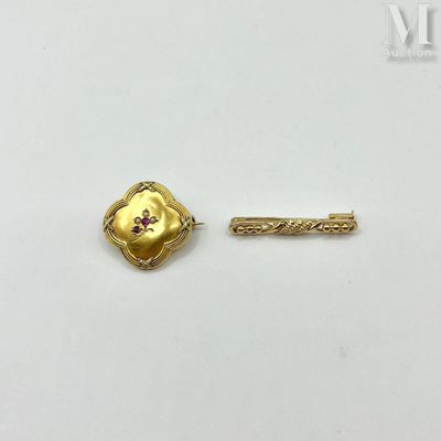 a close up of a gold pin with a flower on it