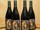 trois bouteilles de vin posées sur un tonneau en bois