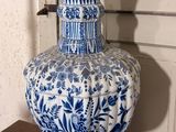 a blue and white vase sitting on a wooden table