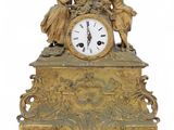 a gold clock with angels on top of it