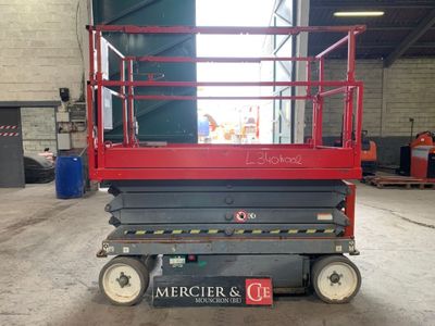 a picture of a red scissor in a warehouse