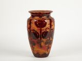 a brown vase with a red design on it