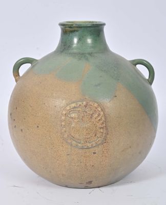 un vase vert et marron muni d'anses, sur fond blanc