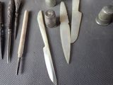 many different types of knifes and other tools laid out on a table