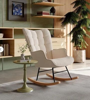 un fauteuil à bascule dans un salon, avec une plante dans un coin