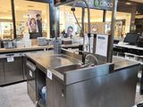 a large stainless steel sink in the middle of a store
