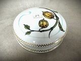 une boîte blanche ornée de fleurs jaunes, posée sur une table