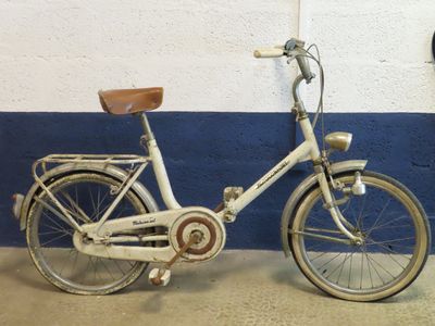 un vélo blanc garé contre un mur bleu et blanc