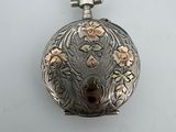 une montre de poche ancienne en argent, ornée d'un motif floral sur le cadran