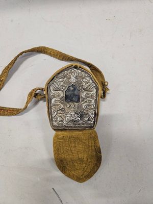 an antique silver and gold purse with a blue stone in the center