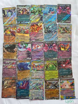a pile of pokemon cards sitting on top of a white sheet