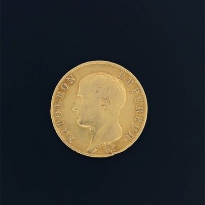 gros plan d'une pièce d'or sur une surface noire