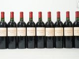 six bouteilles de vin rouge alignées sur une surface blanche