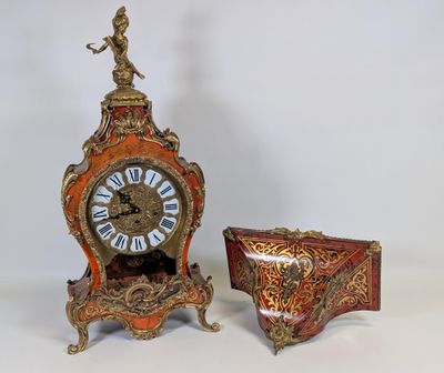 une horloge posée à côté d'une petite boîte sur une table