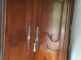a wooden armoire in the corner of a room