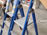three ladders that are sitting in a room