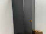 une armoire noire dans un coin d'une pièce, avec des cartons par terre