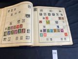un livre ouvert avec des timbres, posé sur une table
