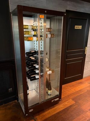 une vitrine contenant des bouteilles de vin, posée sur un plancher en bois