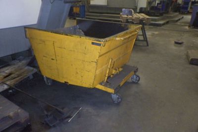 un conteneur jaune posé sur un chariot dans un entrepôt