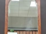un miroir posé sur un pied, dans lequel se reflète une plante