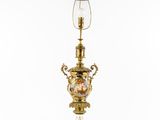 a gold and green lamp with a glass shade on top