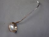 a silver spoon with a handle on a gray surface