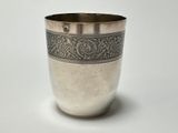 a silver cup that is sitting on a table