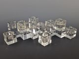 several clear cubes of glass sitting on top of a black surface