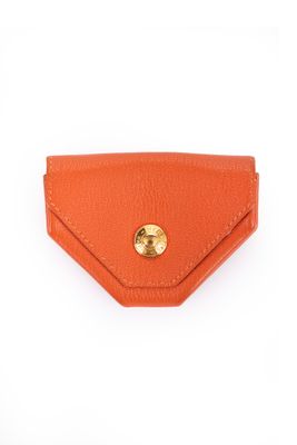 un étui-portefeuille en cuir orange orné d'un bouton doré sur le devant