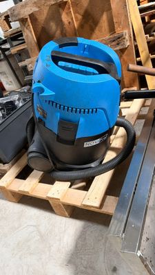 a blue blower sitting on a pallet in a warehouse