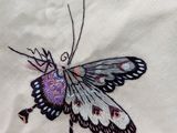 embroidery of a butterfly on a white shirt with a pink and black design