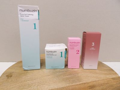 trois boîtes posées sur une table en bois, avec une boîte de dentifrice