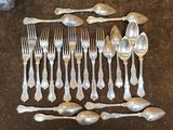de nombreuses cuillères et des cuillères à soupe disposées sur une table