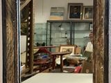 a mirror hanging on the wall with a man in the background