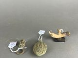 three small figurines sitting on top of a table next to each other