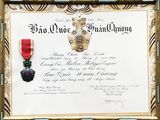 une image représentant un certificat orné d'un ruban rouge et d'une médaille