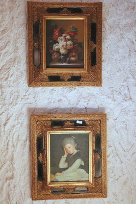 two framed pictures on the wall of a bathroom