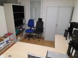 a desk with a computer and a chair in a room