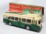 un bus vert et blanc avec une caisse à l'arrière