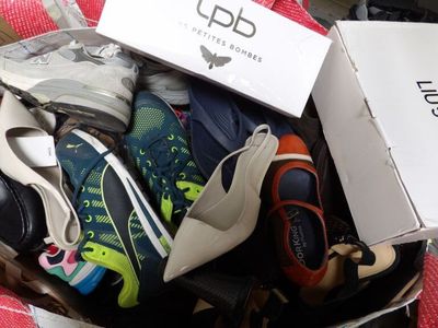 many pairs of shoes in a box on the floor