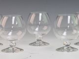 quatre verres à vin vides sont alignés sur une surface blanche