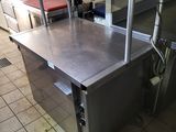 une table de travail en acier inoxydable au milieu d'une cuisine